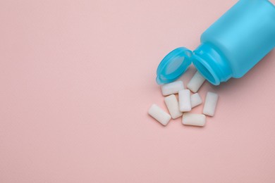 Photo of Jar with chewing gums on light pink background, flat lay. Space for text