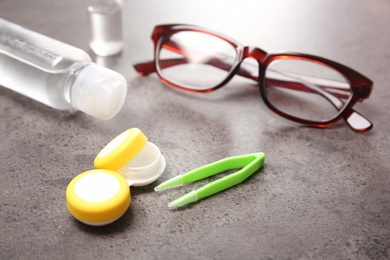 Glasses and contact lens accessories on grey background