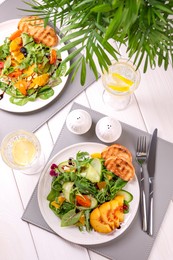 Delicious salad with fruits and vegetables served on white wooden table, flat lay