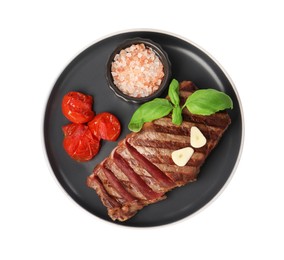 Photo of Delicious grilled beef steak with spices and tomatoes isolated on white, top view