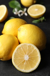 Many fresh ripe lemons on black table, closeup