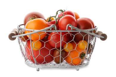 Fresh ripe yellow and red tomatoes in metal basket on white background