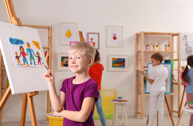 Photo of Cute little child painting during lesson in room