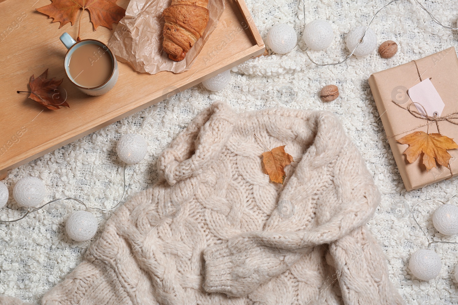 Photo of Flat lay composition with warm sweater on light fabric