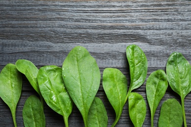 Fresh green healthy spinach on dark wooden table, flat lay