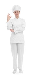 Photo of Happy woman chef in uniform showing OK gesture on white background