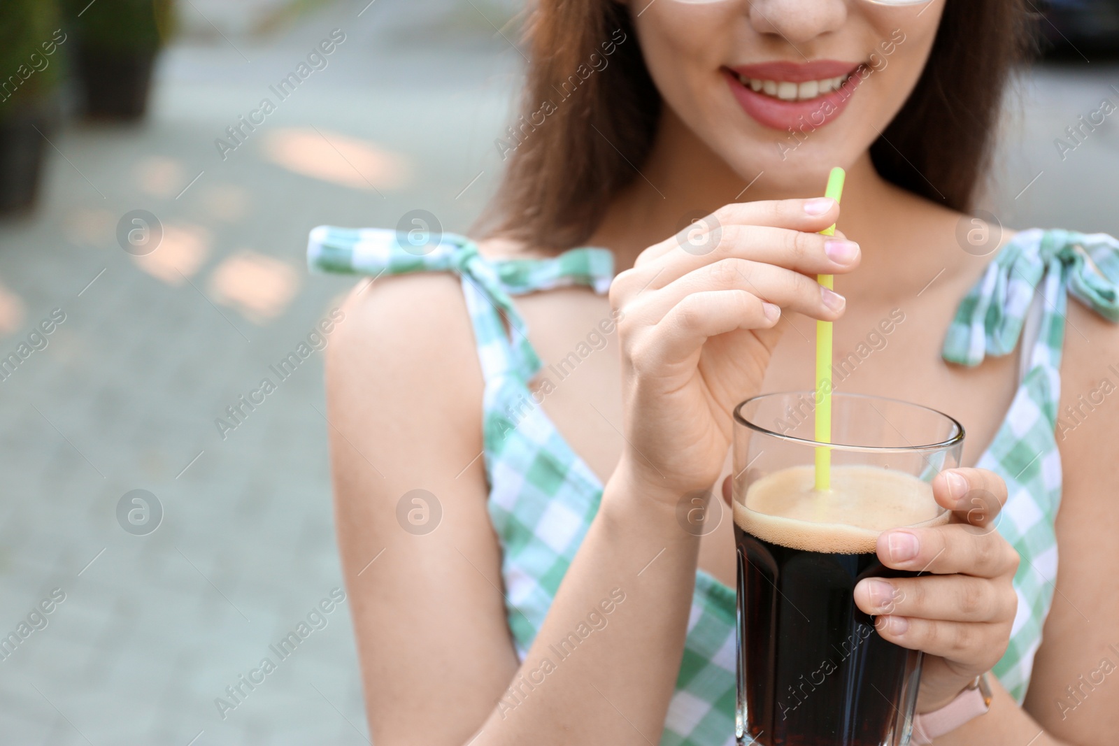 Photo of Young woman with cold kvass outdoors, closeup. Traditional Russian summer drink