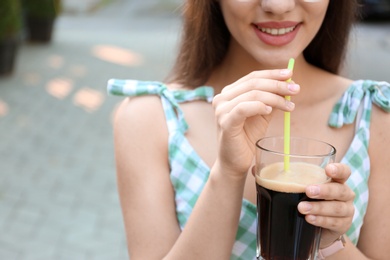 Young woman with cold kvass outdoors, closeup. Traditional Russian summer drink