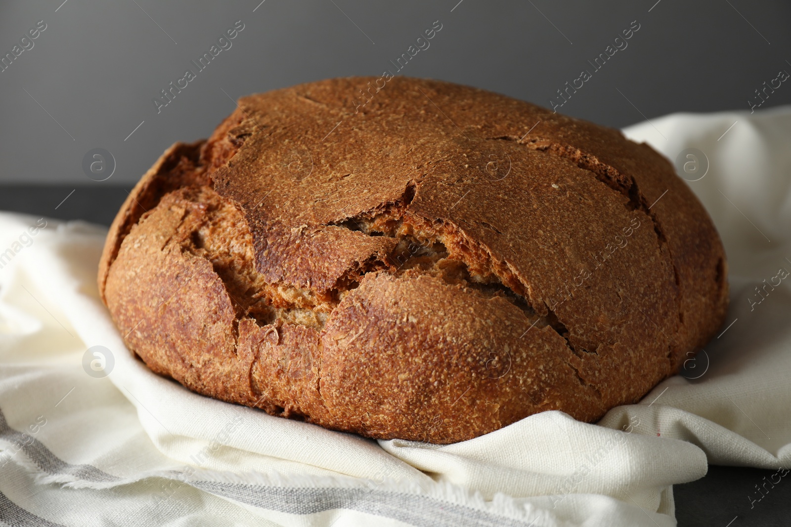 Photo of Freshly baked sourdough bread on table against grey background, closeup