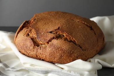 Photo of Freshly baked sourdough bread on table against grey background, closeup