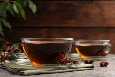 Photo of Aromatic tea with anise stars on light grey table. Space for text
