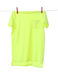 One green t-shirt drying on washing line isolated on white