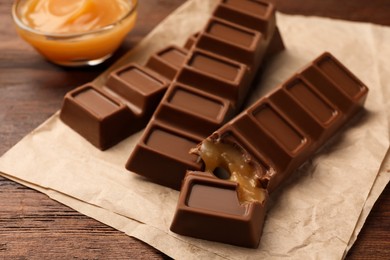 Photo of Tasty chocolate bars on wooden table, closeup