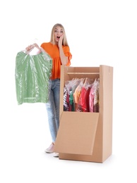 Photo of Young emotional woman near wardrobe box on white background