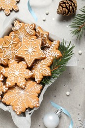 Tasty Christmas cookies and festive decor on light grey table, flat lay