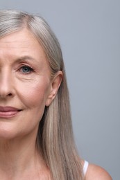 Photo of Portrait of beautiful senior woman on grey background, closeup