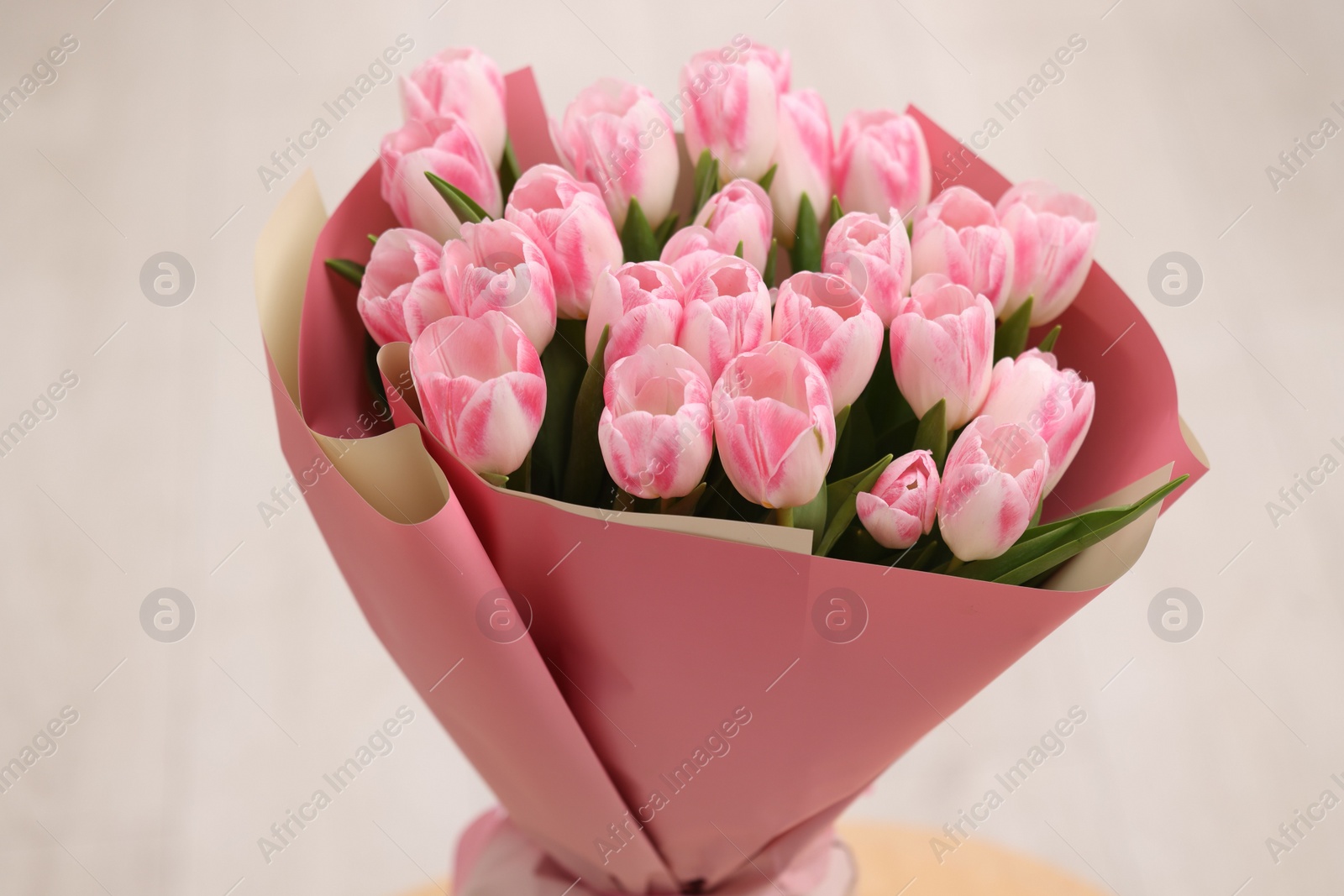 Photo of Beautiful bouquet of fresh pink tulips on blurred background, closeup