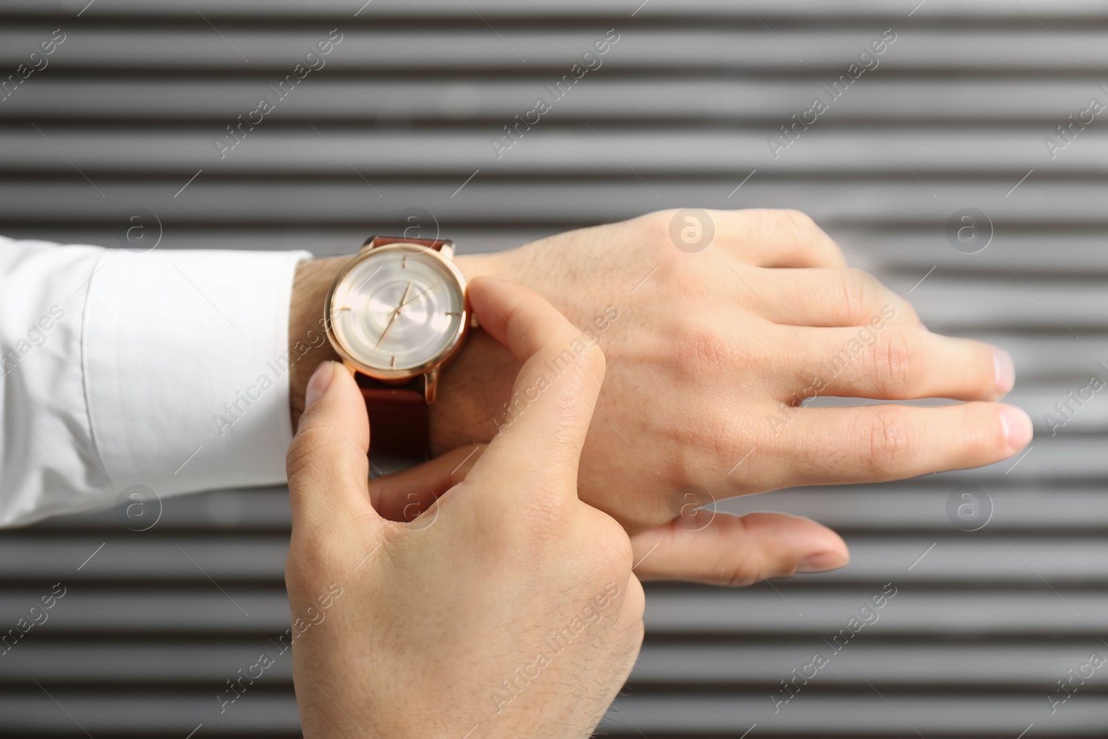 Photo of Man with luxury wrist watch on blurred background, closeup