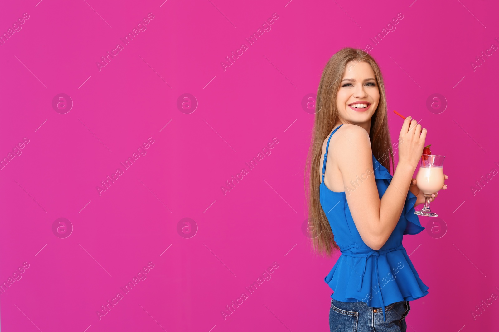 Photo of Young woman with glass of delicious milk shake on color background