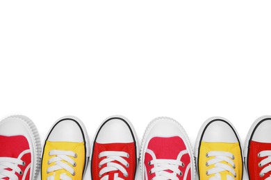 Photo of Yellow and red classic old school sneakers isolated on white, top view