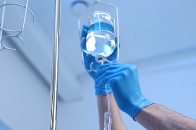 Photo of Nurse setting up IV drip in hospital, closeup