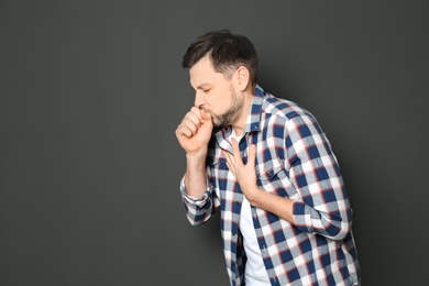 Photo of Mature man suffering from cough on dark background. Space for text