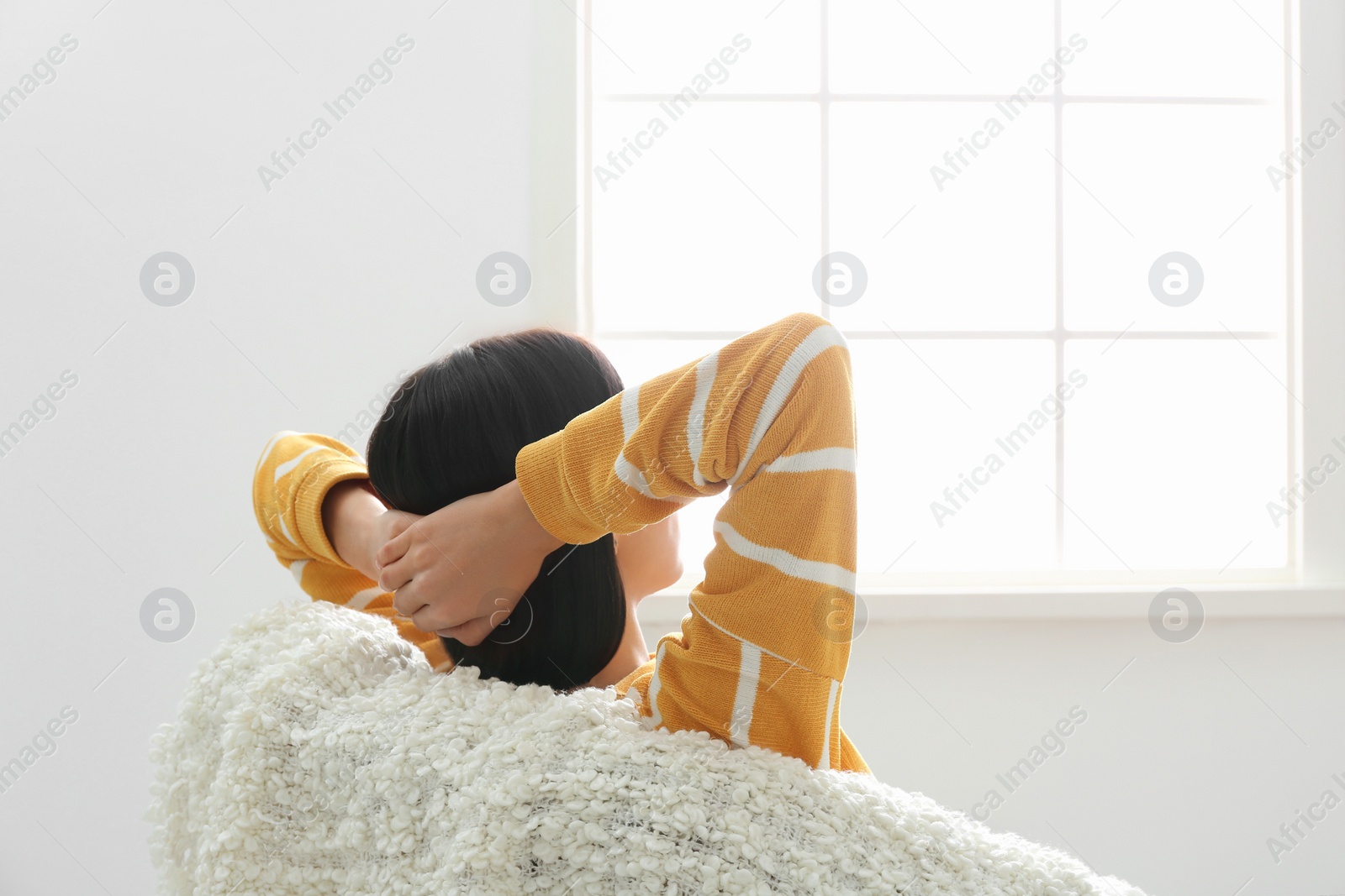 Photo of Young woman relaxing in armchair near window at home