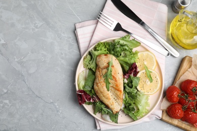 Delicious cooked chicken and fresh salad served on grey marble table, flat lay with space for text. Healthy meals from air fryer