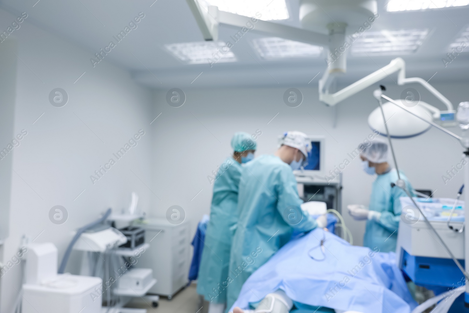 Photo of Blurred view of doctors operating patient in surgery room