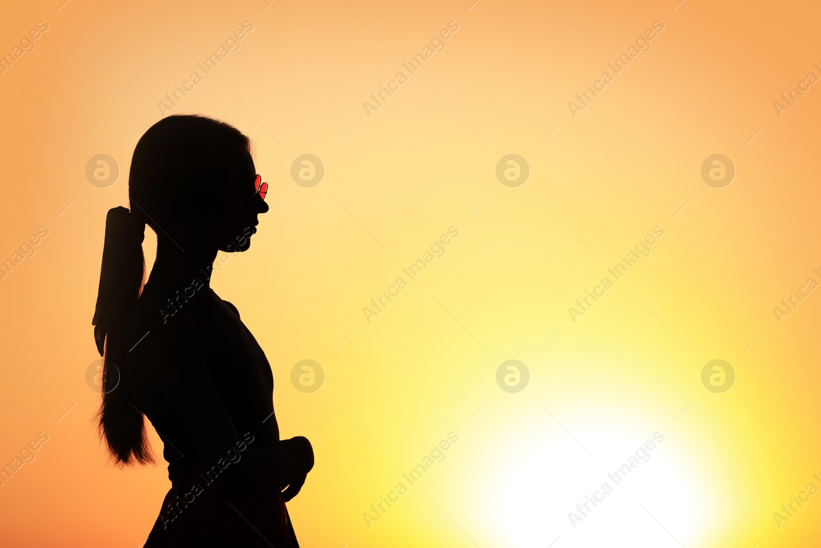 Photo of Silhouette of young woman outdoors at sunset