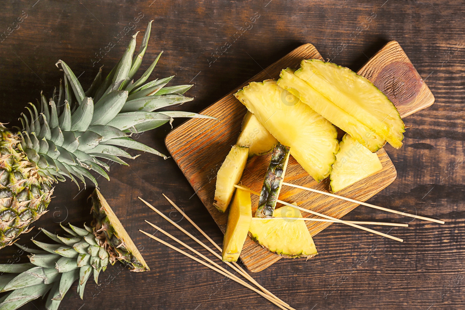 Photo of Fresh pineapples on wooden background