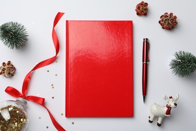 Photo of Red planner and Christmas decor on white background, flat lay. New Year aims