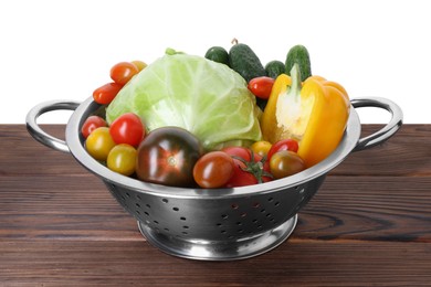 Photo of Metal colander with different vegetables on wooden table against white background