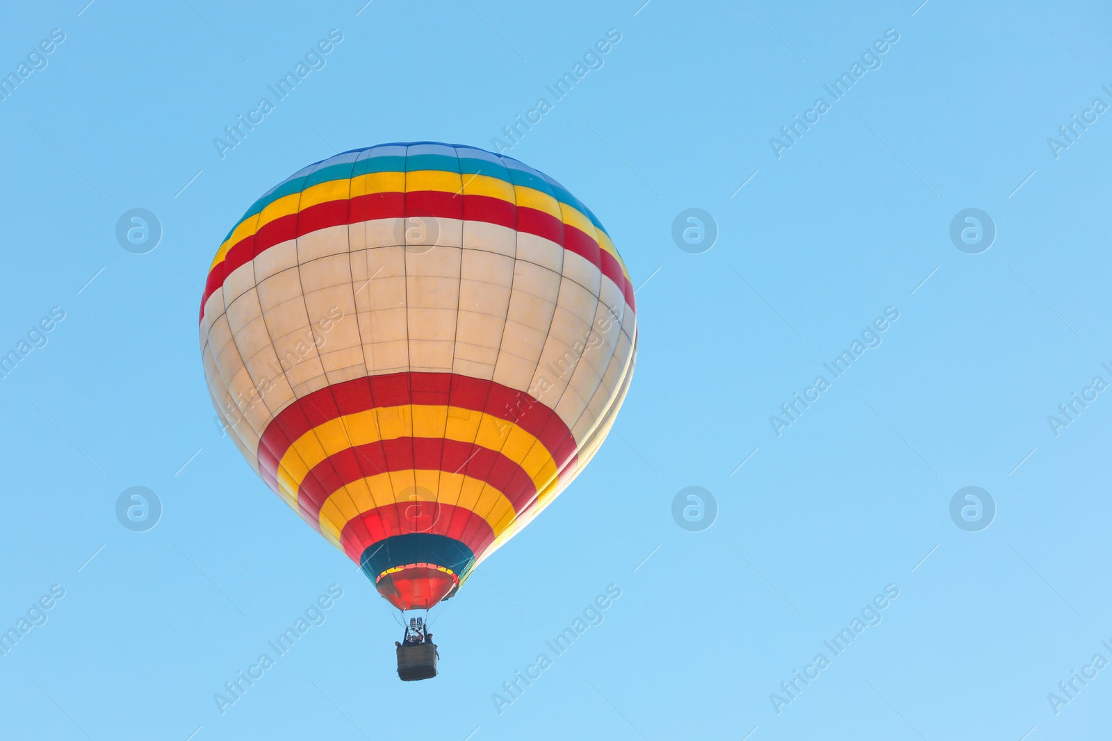 Photo of Colorful hot air balloon flying in blue sky. Space for text