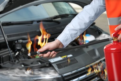 Image of Man with fire extinguisher near car in flame outdoors, closeup