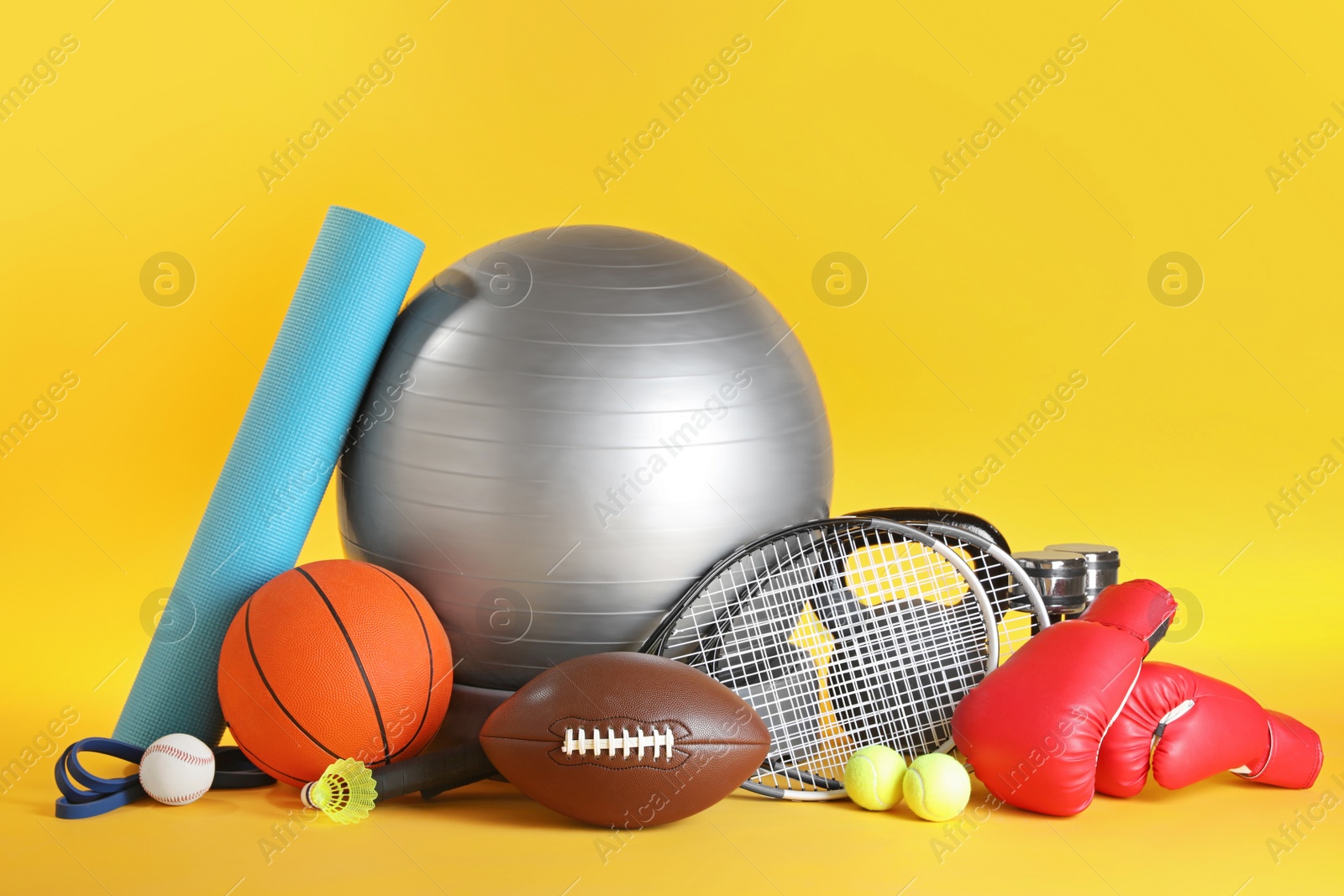 Photo of Set of different sports equipment on yellow background