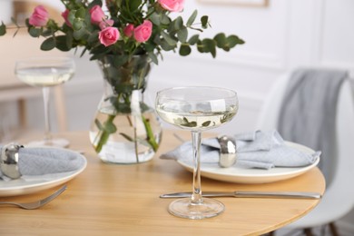 Place setting with pink roses on wooden table. Romantic dinner