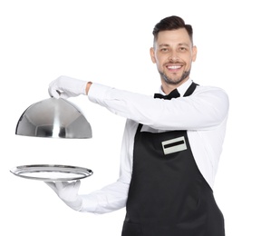 Handsome waiter holding metal tray with lid on white background