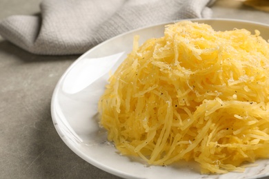 Photo of Plate with cooked spaghetti squash on gray table