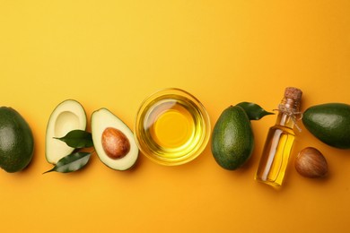 Cooking oil and fresh avocados on yellow background, flat lay