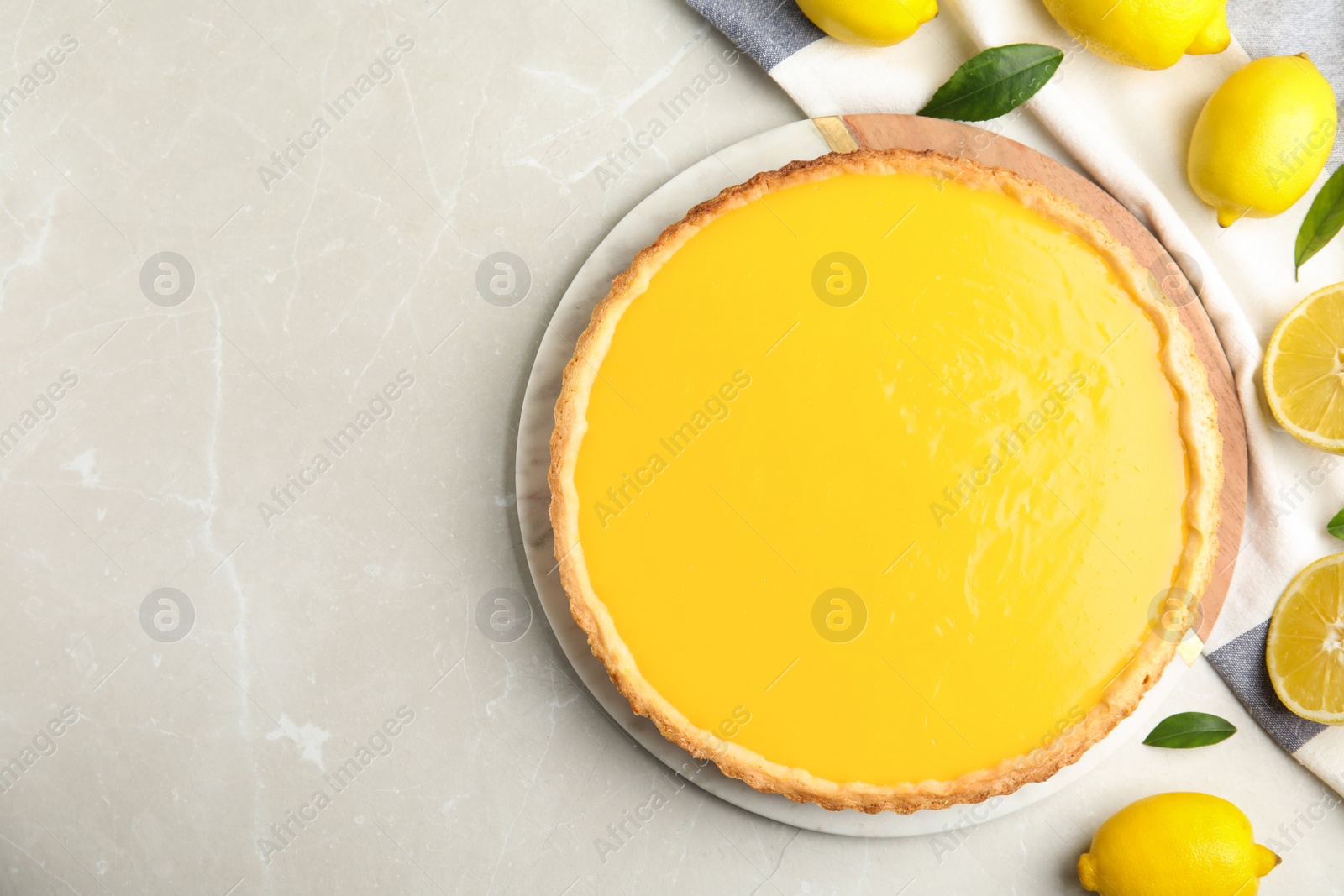 Photo of Delicious homemade lemon pie and fresh fruits on light table, flat lay. Space for text