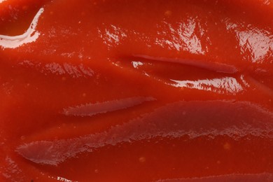 Tasty tomato ketchup as background, top view