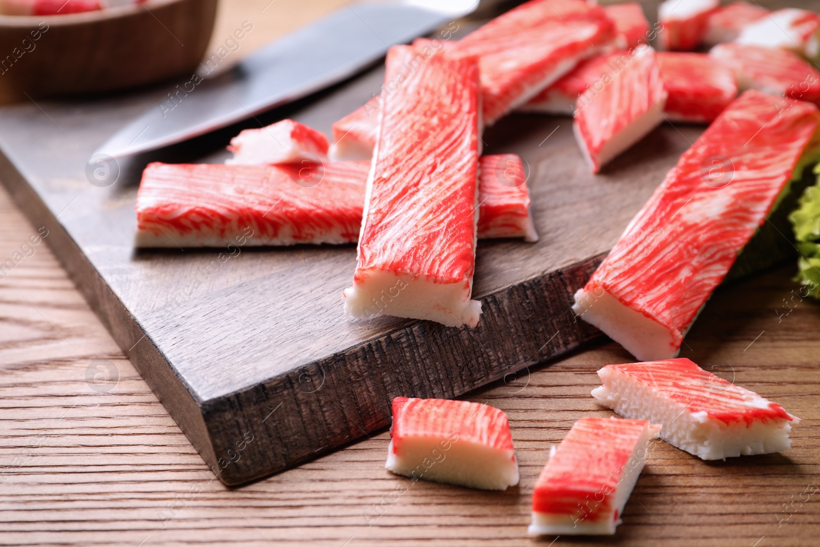 Photo of Delicious crab sticks on wooden table, closeup