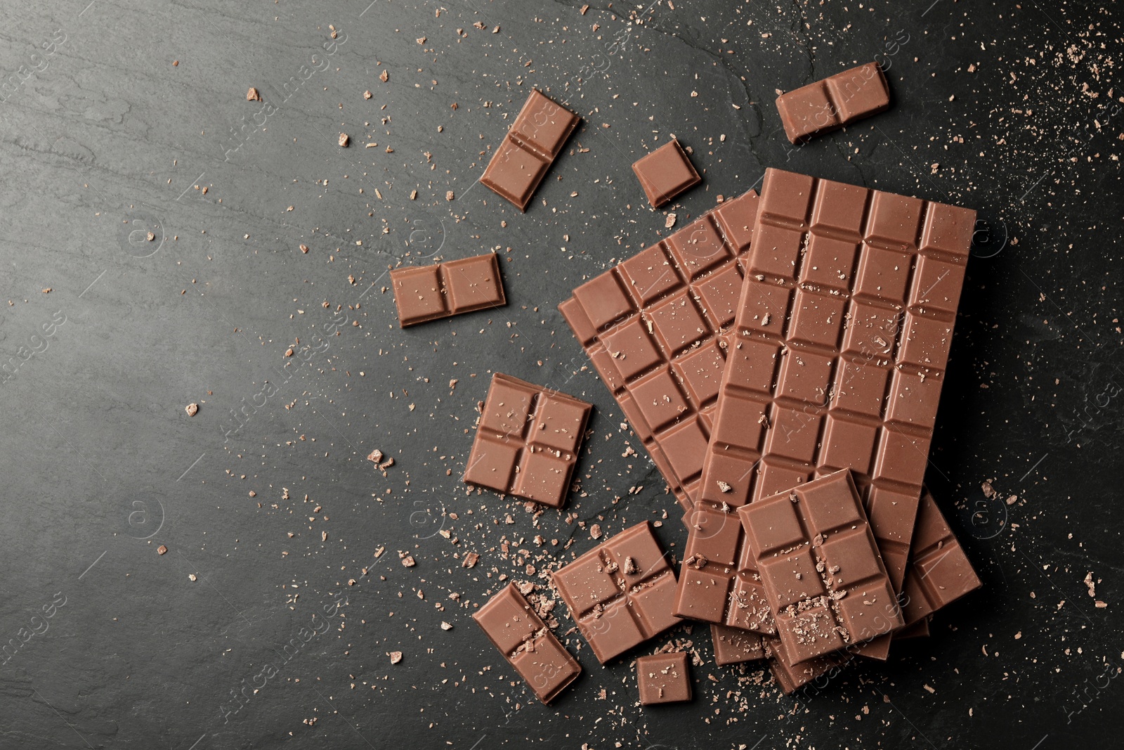 Photo of Pieces of tasty chocolate bars on grey table, flat lay. Space for text