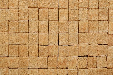 Photo of Brown sugar cubes as background, top view