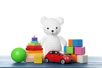 Photo of Different children's toys on blue wooden table against white background