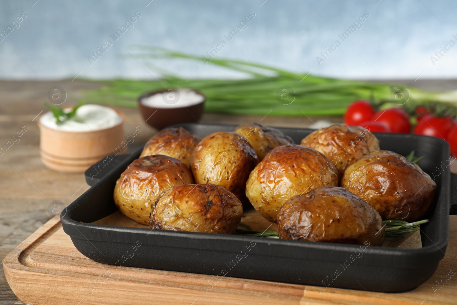 Photo of Delicious hot baked potato with sour cream on wooden table