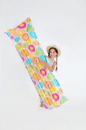 Photo of Cute little child in beachwear with bright inflatable mattress on white background