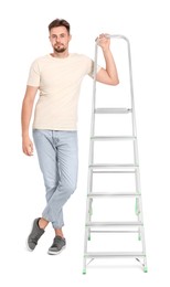 Young handsome man near metal ladder on white background