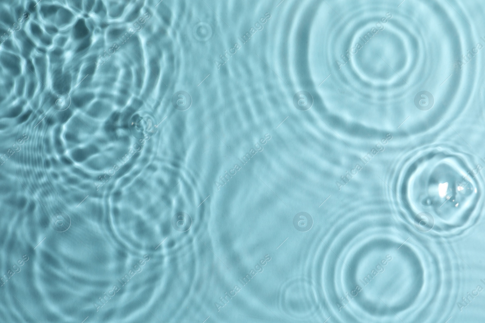 Photo of Closeup view of water with circles on turquoise background